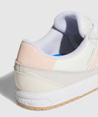 Close-up of a white and pink low-top sneaker with beige suede and textured sole