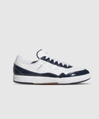 Low-top white and navy sneaker with green accents, perforated toe, and TYSHWN lettering.
