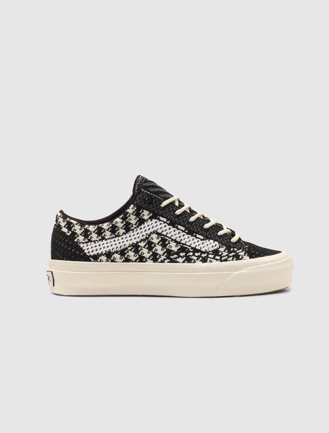 Black and white low-top sneaker with woven pattern, cream sole, and white laces