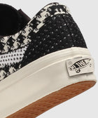 Close-up of black and white woven sneaker heel with logo patch and gum outsole
