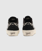 Back view of black and white patterned low-top sneakers with woven heel details