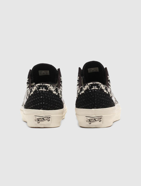 Back view of black and white patterned low-top sneakers with woven heel details