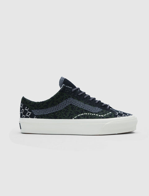 Men's low-top sneaker with black and green cheetah pattern and white sole on white background