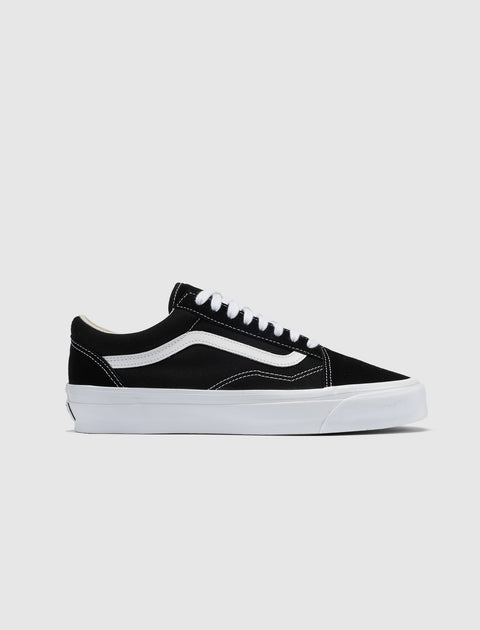 Black and white low-top sneaker with white wave stripe, white laces, and flat sole