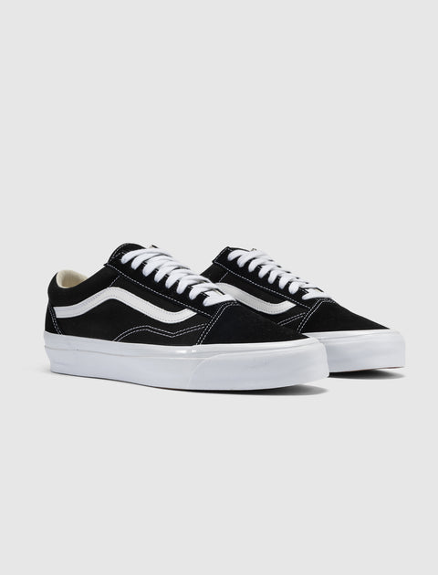 Black and white low-top sneakers with white laces and signature side stripe