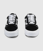 Pair of black and white low-top sneakers with white laces and side stripe on plain background