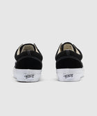 Black and white low-top sneakers with white stitching, viewed from the back on a plain background