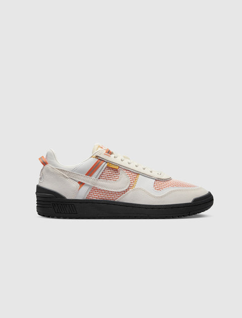 White and orange mesh low-top sneaker with black sole, streetwear style, side view