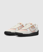 White and orange mesh sneakers with black soles, low-top streetwear shoes side by side