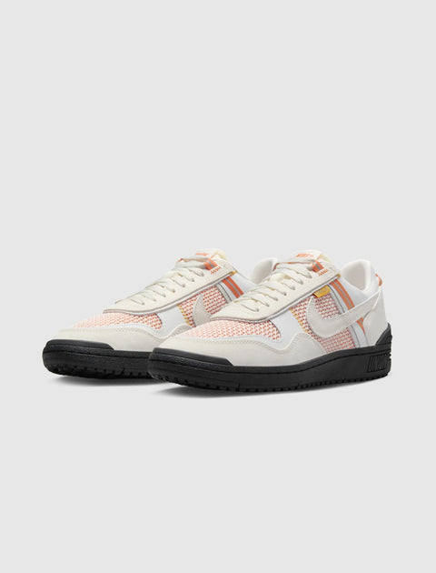 White and orange mesh sneakers with black soles, low-top streetwear shoes side by side