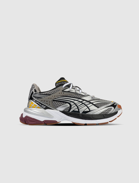 Gray and silver mesh athletic sneaker with black accents, yellow details, and white sole