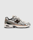 White and beige athletic sneaker with mesh upper, black accents, and visible side logo