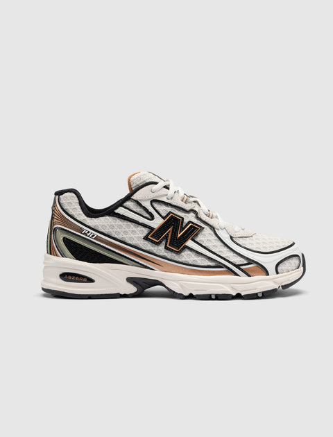 White and beige athletic sneaker with mesh upper, black accents, and visible side logo