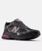 Dark gray and black mesh sneaker with pink accents and reflective details on white background