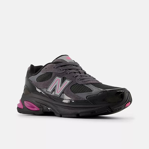 Dark gray and black mesh sneaker with pink accents and reflective details on white background