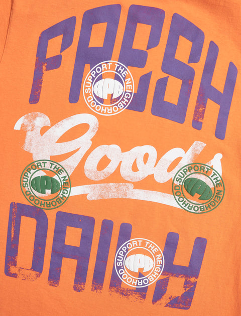 Orange streetwear shirt with bold purple lettering and circular 'Support the Neighborhood' graphics.