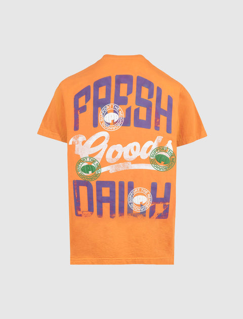 Orange streetwear t-shirt with bold 'FRESH DAILY' and graphic circle text on the back.