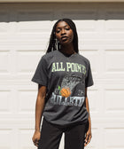 Woman wearing a black streetwear graphic t-shirt with basketball hoop print outdoors