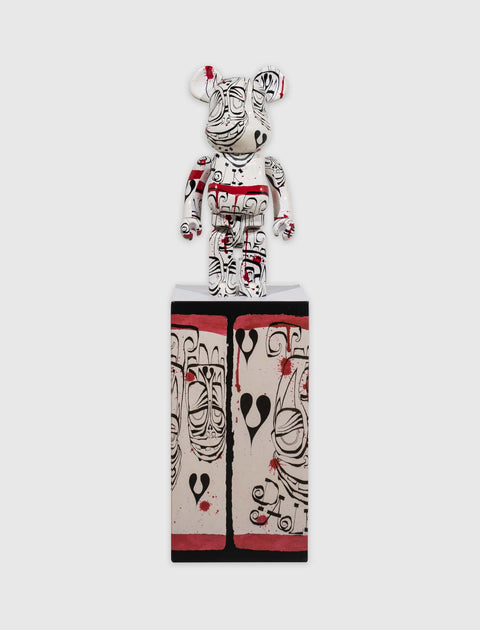 Artistic bear figurine with abstract black, red, and white designs on a matching box