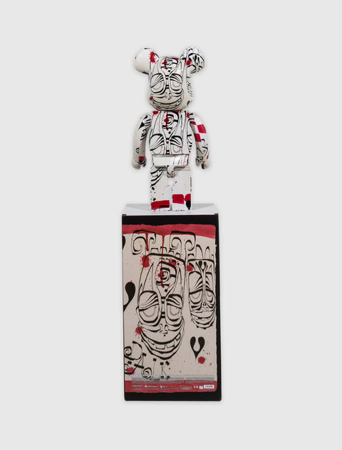 Urban art bearbrick figure with abstract black and red designs, standing on graphic box