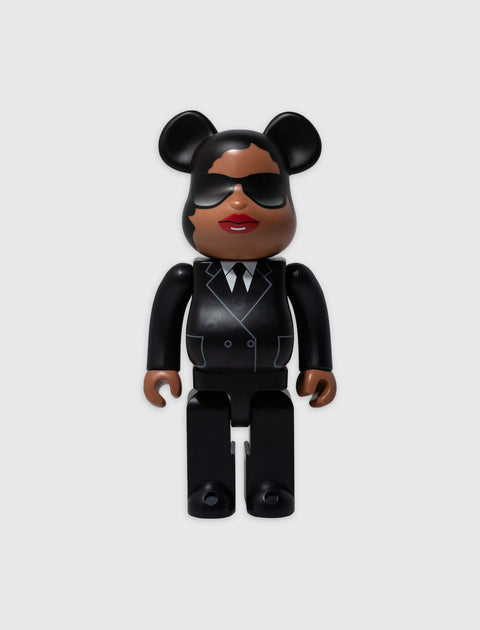 Bearbrick style collectible toy figure in black suit, sunglasses, and mouse ears on plain background