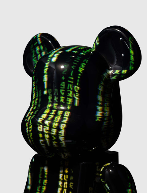 Glossy black bear-shaped collectible figure with green and yellow Matrix code design