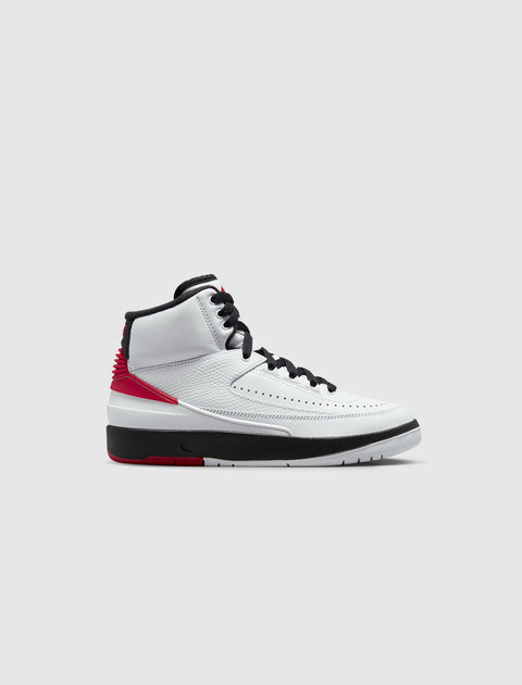 White high-top sneaker with black laces, red accents, and black and white sole on plain background