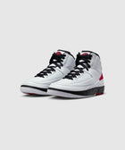 White and red high-top sneakers with black laces on a simple gray background