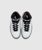 White high-top sneakers with black laces and red accents, viewed from above.