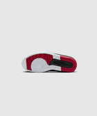 Red, black, and white sneaker sole with circular tread pattern on a light background