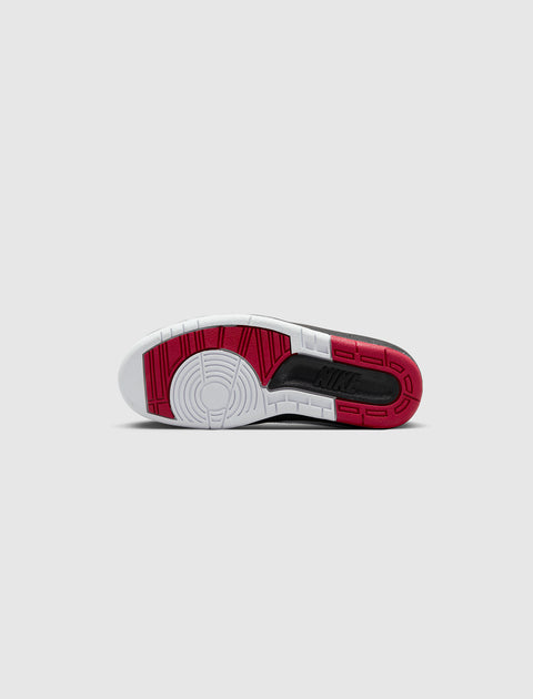 Red, black, and white sneaker sole with circular tread pattern on a light background