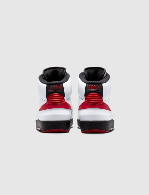 Rear view of white, red, and black Nike high-top sneakers on light gray background