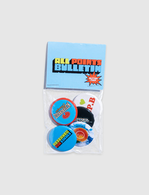 Pack of colorful pinback buttons with graphic streetwear designs on a light background