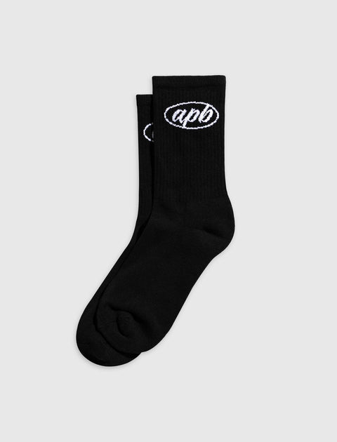 Black crew socks with white embroidered apb logo, laid flat on plain background