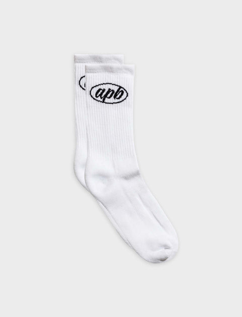Pair of white crew socks with black apb logo embroidery on ankle, streetwear style