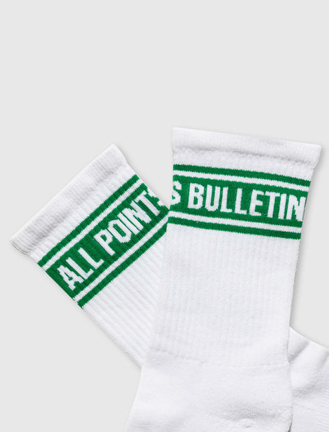 White crew socks with green stripes and ALL POINTS BULLETIN text detail