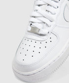Close-up of white low-top sneaker with perforated toe box and white laces