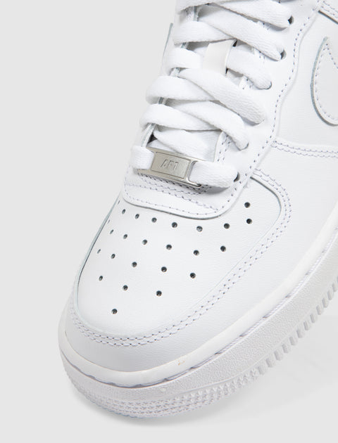 Close-up of white low-top sneaker with perforated toe box and white laces
