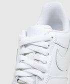 Close-up of white low top sneaker with white laces and stitched side logo