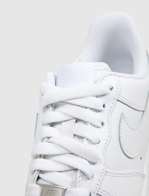 Close-up of white low top sneaker with white laces and stitched side logo