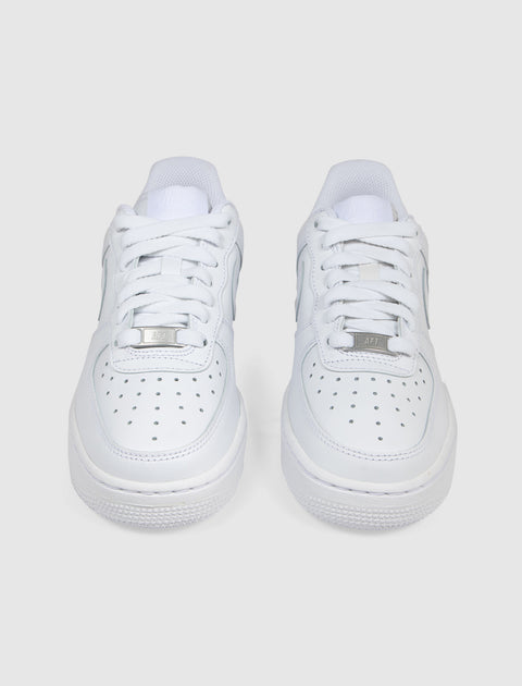 Pair of white low-top sneakers with perforated toe box and white laces, on plain background