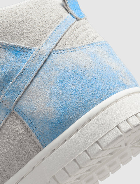 Close-up of high-top sneaker heel in light blue and grey suede with white sole.