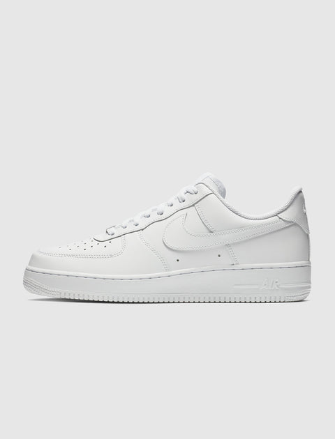 White low-top sneaker with perforated toe and side Swoosh logo on plain background