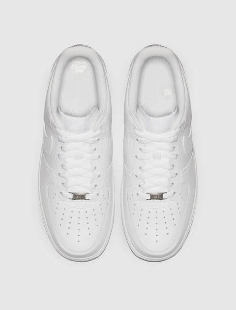 Top view of classic white low-top sneakers with perforated toes and white laces.