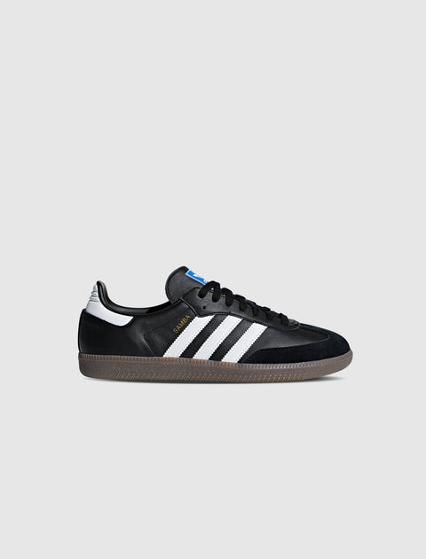 Black and white low-top sneaker with gum sole and three side stripes, isolated on white