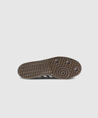 Brown gum sole sneaker with textured grip and branding on the outsole, displayed bottom view.