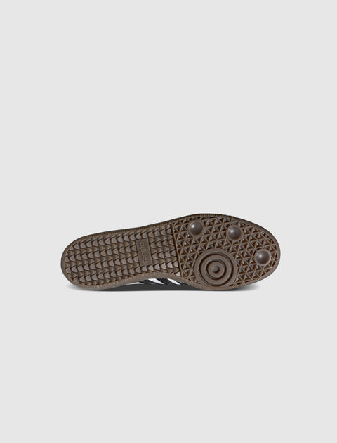 Brown gum sole sneaker with textured grip and branding on the outsole, displayed bottom view.