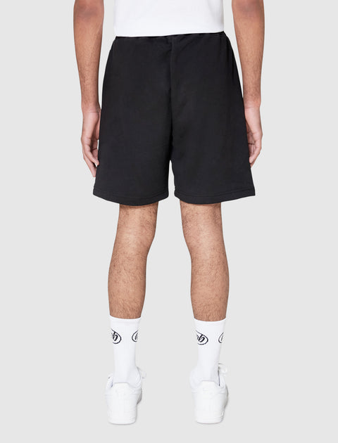 Back view of man wearing black streetwear shorts, white socks, and white sneakers